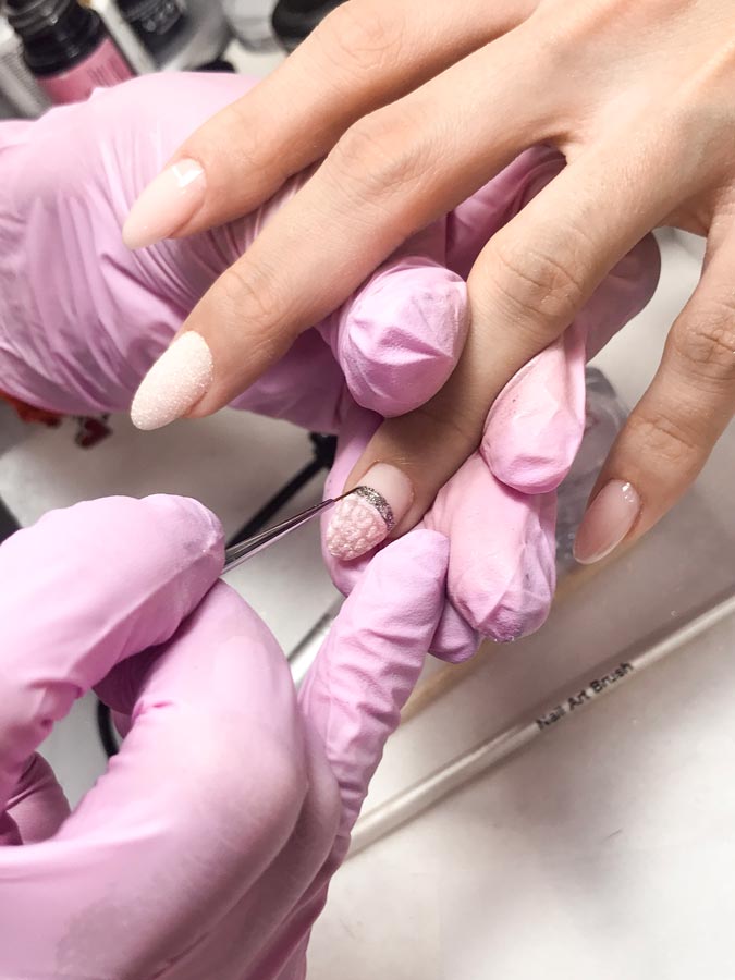 На нігті, які не займані посипкою, наносимо останній топовий шар і сушимо все пальці в УФ-лампі