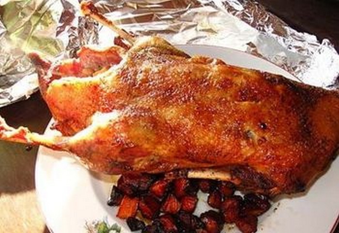 тушка качки вагою 2 кг;   0,6-0,8 кг картоплі;   пара середніх морквин;   пара головок ріпчастої цибулі;   сіль;   кілька часточок часнику;   мелений перець;   рукав для запікання